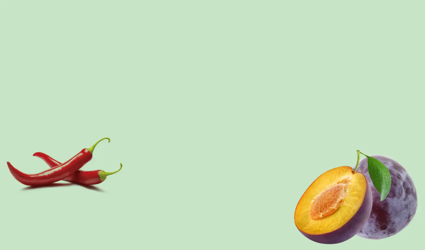Half-cut plum with a chili pepper on a light green background
