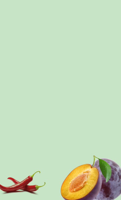 Half-cut plum with a chili pepper on a light green background